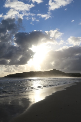 The sun streams through the clouds at Byron Bay in Australia.